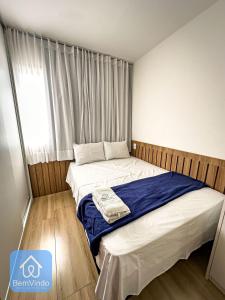 - une chambre avec un lit doté d'une couverture bleue dans l'établissement Estadia Confortável: Studio no Smart Pituba, à Salvador