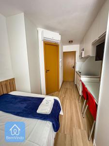 a small room with a bed and a yellow door at Estadia Confortável: Studio no Smart Pituba in Salvador
