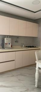 a kitchen with white cabinets and a sink at شاليه تريك in Buraydah
