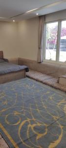 a room with a carpet with a bed and a window at شاليه تريك in Buraydah