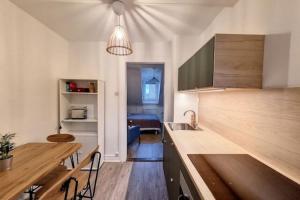 a kitchen with a sink and a table with a counter at Cosy Rent Strasbourg saint Florent proche Gare in Strasbourg