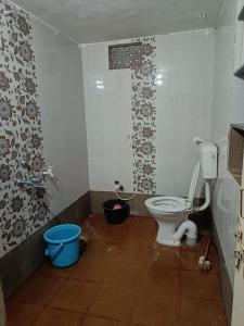 baño con aseo y cubo en Kittur Guest House, en Dharwad