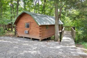 a small wooden cabin with a ramp in the woods at Rustic Cabin in Lake Monroe in Bloomington