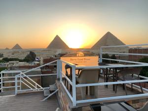 una terrazza con tavolo e vista sulle piramidi di un hotel di Horus Guest House Pyramids View a Il Cairo
