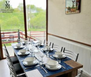 une table en bois avec des assiettes et des verres dans l'établissement Villa Mtashi, à Bakuriani