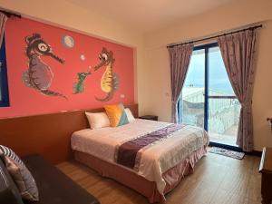 a bedroom with a bed with a painting of seahorses on the wall at Blue Bay in Green Island