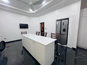 eine Küche mit einer weißen Theke und einem Kühlschrank in der Unterkunft Luxe Club in Cotonou