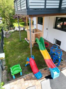 un patio trasero con un parque infantil con un tobogán en Apart Aurelia en Längenfeld