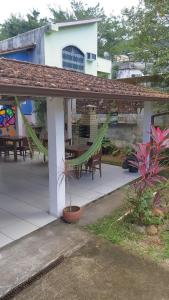a house with a patio with a table and chairs at Aconchego da Vila in Mangaratiba
