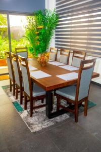 uma mesa de jantar em madeira com cadeiras e sidx sidx em La pépite em Cotonou