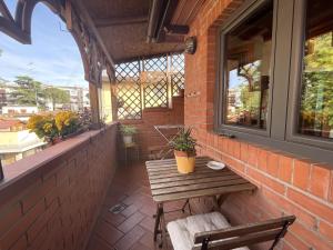 een patio met een houten tafel en banken aan een bakstenen muur bij Apartment Torri in Florence