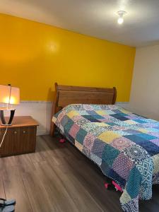 una camera con un letto e una parete gialla di Surrey central bedroom a Surrey