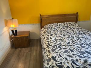 una camera con un letto e una lampada su un tavolo di Surrey central bedroom a Surrey