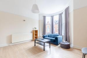 een woonkamer met een blauwe bank en een tafel bij Roomy 3BD by Hampstead Heath! in Londen