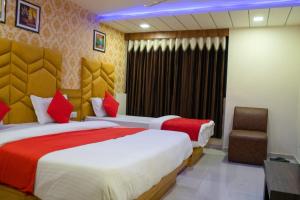 Hotel Landmark inn في أحمد آباد: غرفة فندقية بسريرين وكرسي