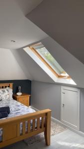 a bedroom with a bed and a skylight on the ceiling at Old Nurses Cottage in Skeabost