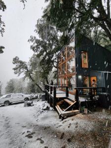 馬拉卡維尤的住宿－Lodge Rincon del Bosque, Malalcahuello，雪中的房子,旁边停着一辆汽车