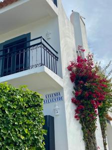 ein weißes Gebäude mit einem Balkon und Blumen darauf in der Unterkunft Vivenda Silvestre in Albufeira