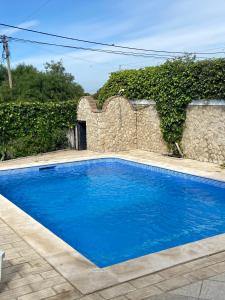 una piscina blu di fronte a un muro di pietra di Vivenda Silvestre ad Albufeira