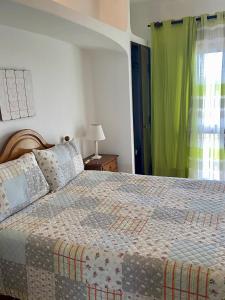 a bedroom with a bed and a green curtain at Vivenda Silvestre in Albufeira