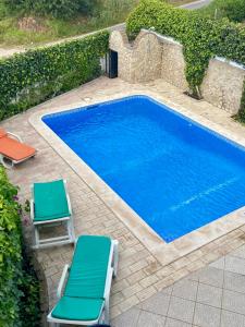 une piscine avec deux chaises longues et une piscine dans l'établissement Vivenda Silvestre Family House, à Albufeira