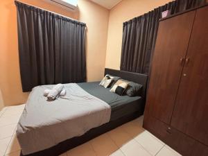 a small bedroom with a bed and a cabinet at Citadil Homestay in Miri