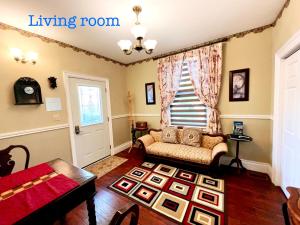 uma sala de estar com um sofá e uma janela em Grape Suite-heart of oldtown em Niagara-on-the-Lake
