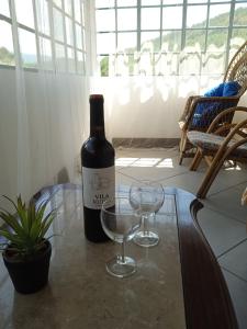 una bottiglia di vino e due bicchieri su un tavolo di Casa Pintarolas a Lousã