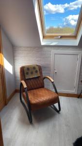 a chair sitting in a room with a window at Old Nurses Cottage in Skeabost