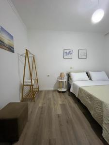 a bedroom with two beds and a wooden floor at ML Apartment Saranda in Sarandë
