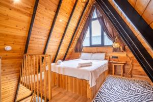 um quarto num chalé de madeira com uma cama e uma janela em Karaöz Sapphire Bungalows em Kumluca