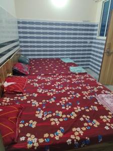- un lit avec une couette rouge et des fleurs dans l'établissement Shri govind bhawan, à Vrindavan