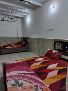 Cette grande chambre comprend un lit et un écran de projection. dans l'établissement Shri govind bhawan, à Vrindavan