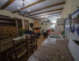 a kitchen and living room with a stove and a fireplace at Casa Rural Padre Ramon in Laroya