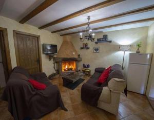 a living room with two couches and a fireplace at Casa Rural Padre Ramon in Laroya