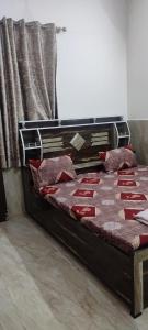 - un lit avec des oreillers rouges et un cadre en bois dans l'établissement Shri govind bhawan, à Vrindavan