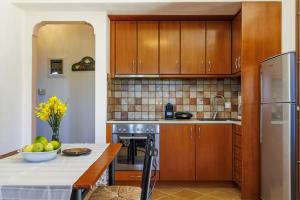 una cocina con armarios de madera y una mesa con un bol de fruta en Naiades superior apartments in Skopelos with sea view close to the town, en Skopelos Town