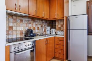 una cucina con armadi in legno e frigorifero bianco di Naiades superior apartments in Skopelos with sea view close to the town a Skopelos Town