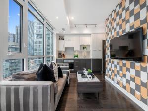 a living room with a couch and a tv at Designer Two Bedroom Suite. in Toronto