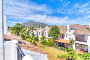 einen Blick von einem Balkon aus auf Häuser mit einem Berg im Hintergrund in der Unterkunft Serenity Luxury , Puerto Banús Marbella in Marbella