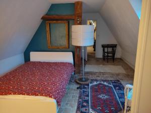 a bedroom with a bed with a lamp and a staircase at La Coquerie in Fondettes