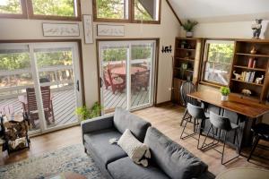 un soggiorno con un divano e un tavolo di Chalet w Hot Tub, Grill, FirePit, WiFi,PetFriendly a Morton Grove