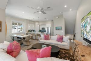 a living room with a white couch and pink pillows at Surf Hut at Palmilla Beach in Port Aransas
