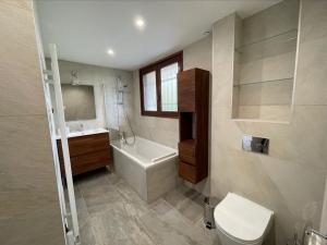 ein Badezimmer mit einem WC, einer Badewanne und einem Waschbecken in der Unterkunft Chalet de la buche croisée in Combloux