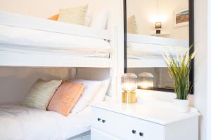a bedroom with white bunk beds and a mirror at Northern Hideaways, Castle View in Bellingham