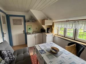 ein Wohnzimmer mit Tisch und Küche in der Unterkunft Friesenhof Küper in Dagebüll