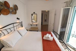 una camera da letto con un letto bianco e uno specchio di Celeste Apartments a Ornos