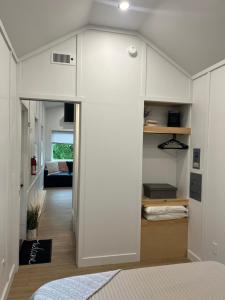 een slaapkamer met witte muren en een kamer met een bed bij The Overlook Tiny Home in Elizabethtown