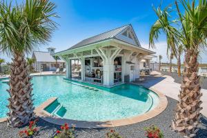 a swimming pool with a gazebo and palm trees at Surf Hut at Palmilla Beach in Port Aransas