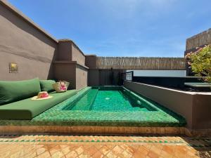 een zwembad aan de zijkant van een gebouw bij Riad Belharra in Marrakesh